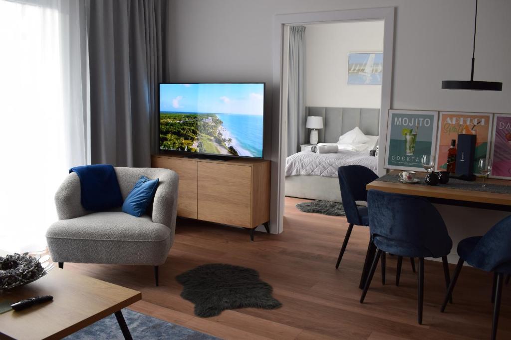 een woonkamer met een tv en een slaapkamer bij Isla Mechelinki in Pierwoszyno