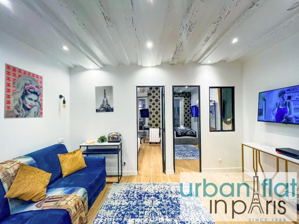 un salon avec un canapé bleu et une table dans l'établissement 15 - Coco Chanel Montorgueil, à Paris