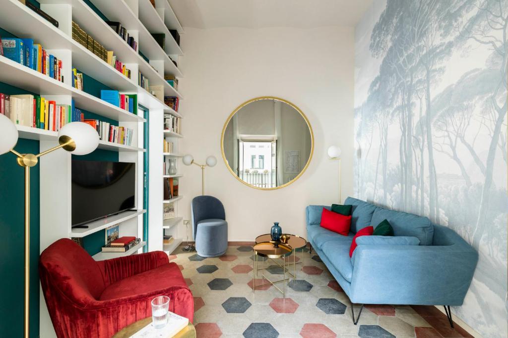 a living room with a blue couch and a mirror at YCH-Colosseo book house in Rome