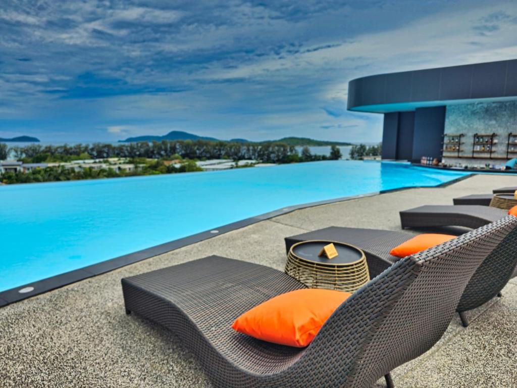 a swimming pool with chairs and a table and a swimming pool at Duplex Luxury Apartments in 5 Star Hotel in Rawai Beach