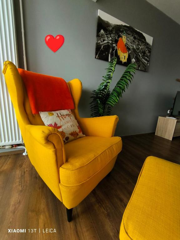 ein gelber Stuhl steht in einem Wohnzimmer in der Unterkunft Apartman Lamarti in Samobor