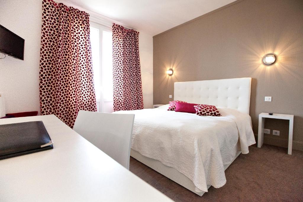 a bedroom with a white bed and a window at Hôtel Radio - Teritoria in Chamalières