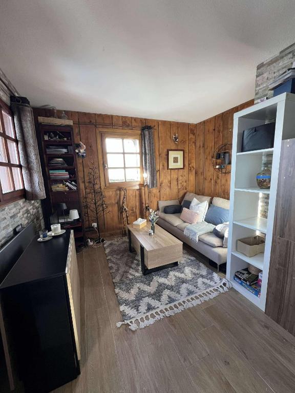 un salon avec un canapé et une table dans l'établissement Ali'Home vue MontBlanc - T2 de charme, à Demi-Quartier
