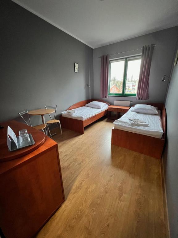 a room with two beds and a desk and a table at Akademia Tenisa Prawobrzeże in Szczecin