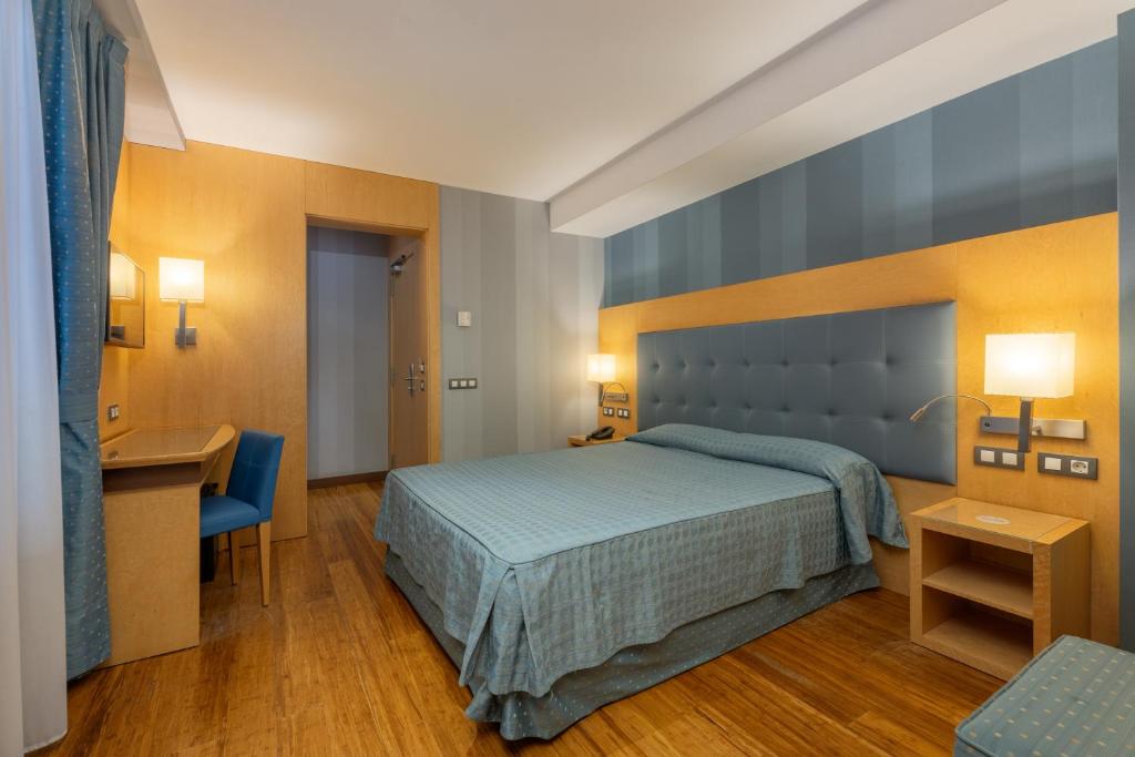 a hotel room with a bed and a desk at Hotel del Mar in Barcelona