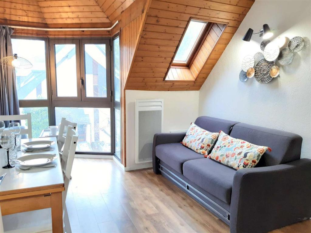 un salon avec un canapé et une table dans l'établissement Charmant T2 Sud avec Bow-Window, TV, Kitchenette Équipée, Muscu, Sauna, Jacuzzi—Proche St-Lary Soulan - FR-1-457-284, à Vignec