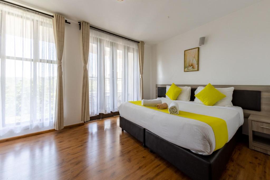 a large bedroom with a large bed with yellow pillows at Erica Residences - Riverside in Nairobi