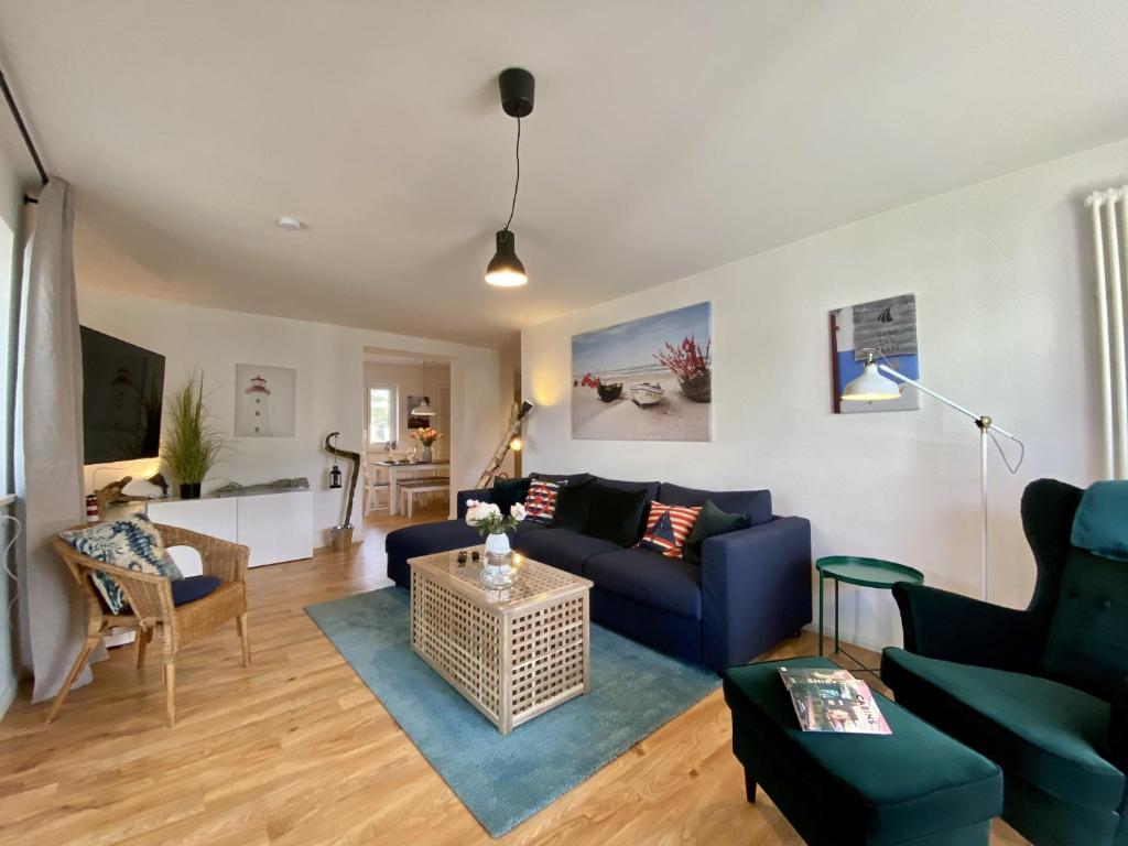 Ferienwohnung Küstenkind im Haus Strandbummler Baabe في بابي: غرفة معيشة مع أريكة زرقاء وطاولة