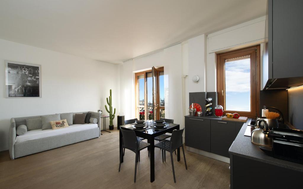 a kitchen and living room with a table and a couch at LA TERRAZZA VISTA DUOMO, piscina e campi da tennis in Milan