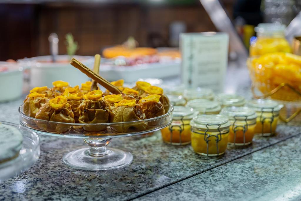 a plate of food on a counter with jars of honey at Hotel Rialto in Barcelona