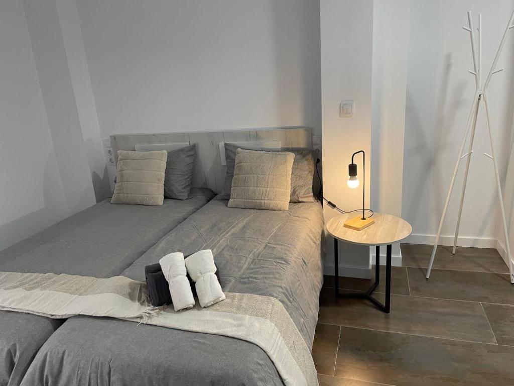 a bed with two pillows and a table in a room at Gómez-Tortosa Apartamento in Novelda