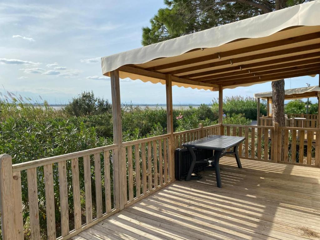 - une terrasse en bois avec une table de pique-nique sous un pavillon dans l'établissement Joli Mobil-home spacieux Mar Estang, à Canet