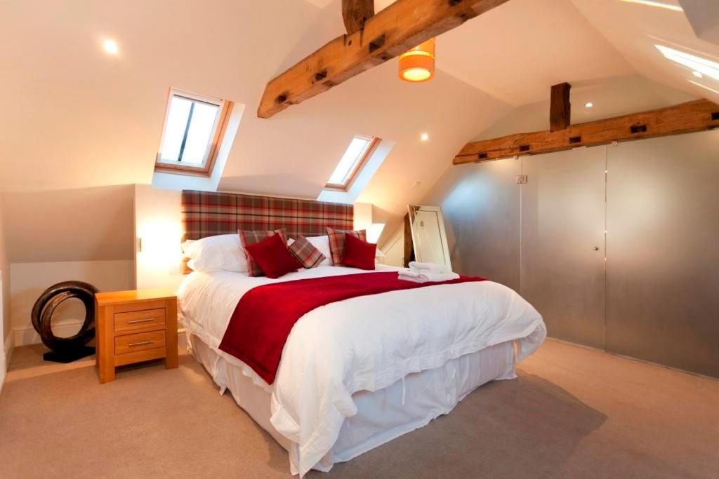 um quarto com uma cama grande e um cobertor vermelho em Dbs Serviced Apartments em Castle Donington