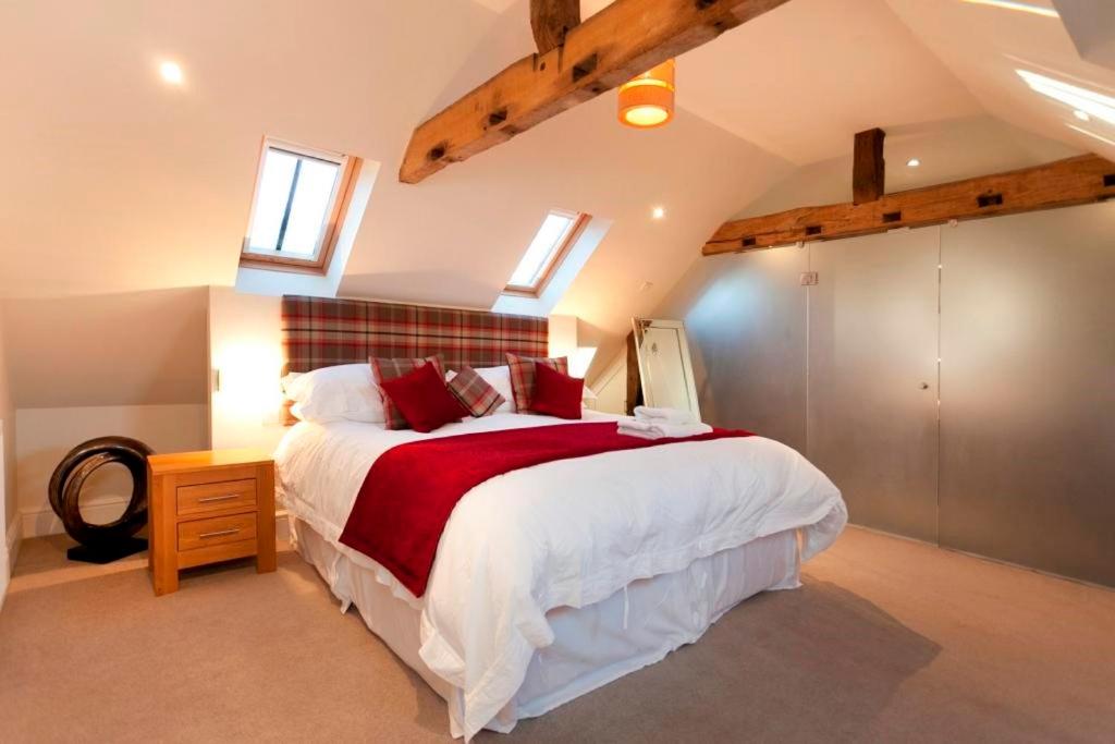 una camera da letto con un grande letto con una coperta rossa di Dbs Serviced Apartments a Castle Donington