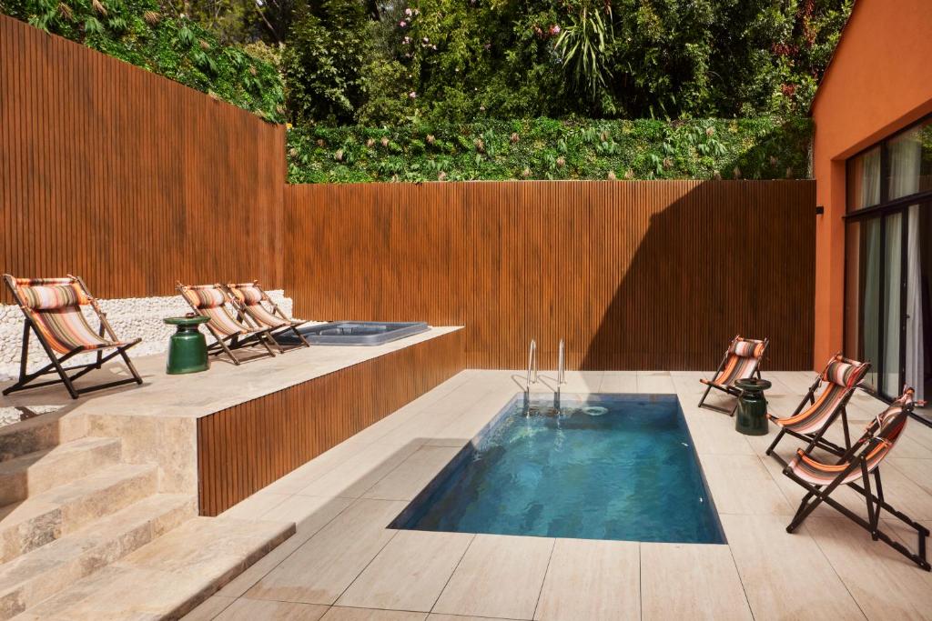 a swimming pool in a patio with chairs and a fence at EZE BEACH Residence in Éze