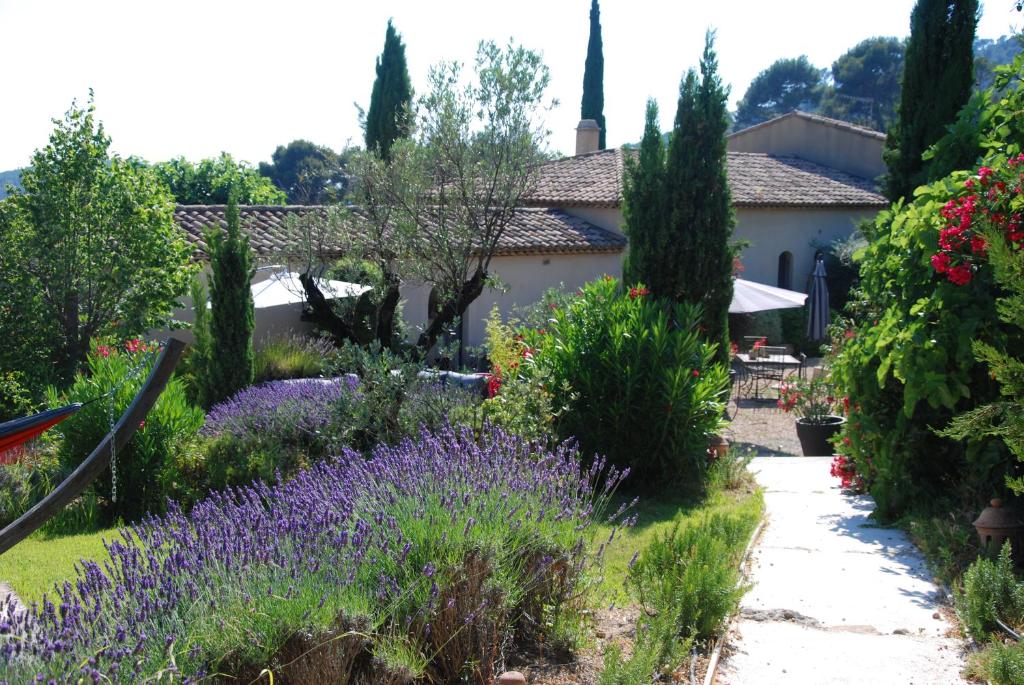 un jardín frente a una casa con flores púrpuras en Le Clos de la Chèvre Sud, en La Cadière-dʼAzur