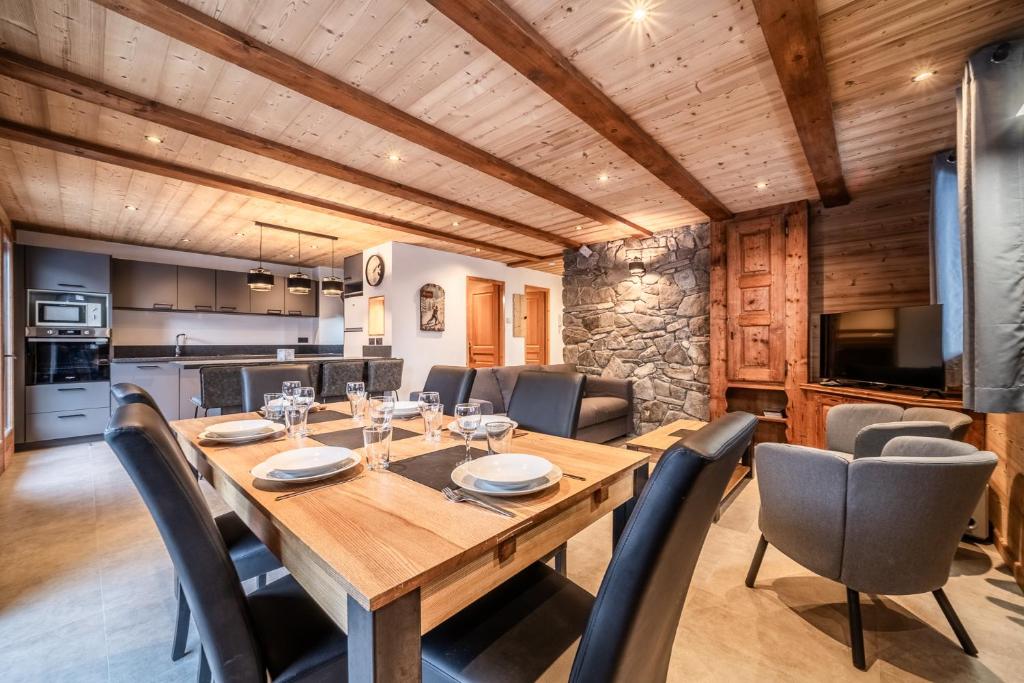 Una cocina y un comedor con mesa y sillas de madera. en LES SERMES M304, en Morzine