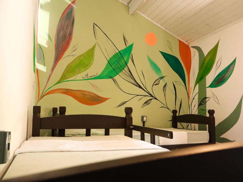 a bedroom with a painting on the wall at Pousada e Hostel Marthi in Ubatuba
