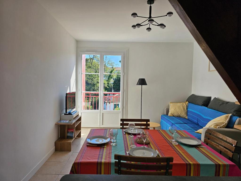 un salon avec une table et un canapé bleu dans l'établissement Le fronton, à Saint-Jean-de-Luz