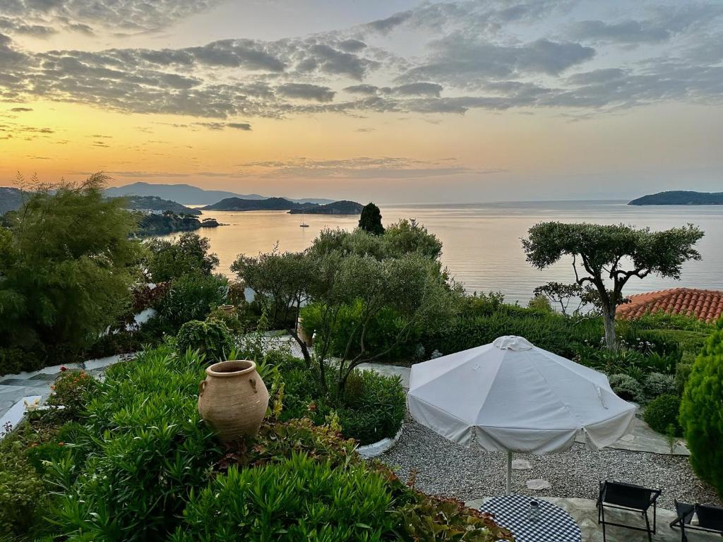 a white umbrella and a vase sitting next to the water at Villa Athena Skiathos in Megali Ammos