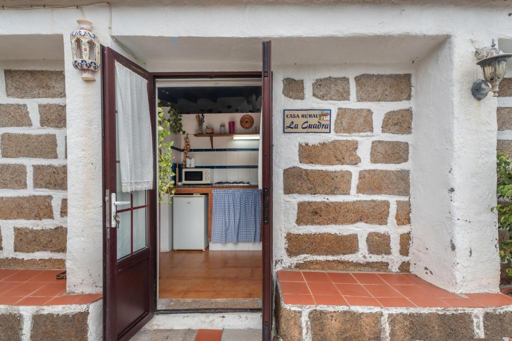 an open door to a kitchen in a brick wall at Casa Rural La Cuadra in Hermigua
