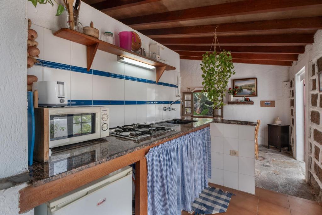 a kitchen with a stove and a microwave at Casa Rural La Cuadra in Hermigua