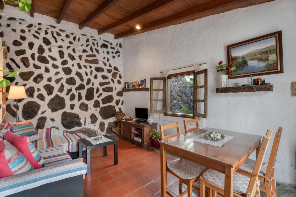 a living room with a table and a dining room at Casa Rural La Cuadra in Hermigua