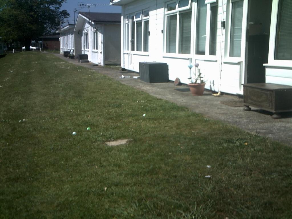 a yard in front of a house with a grass yard at Moulin Rouge three rooms heated cabin in Dartmouth