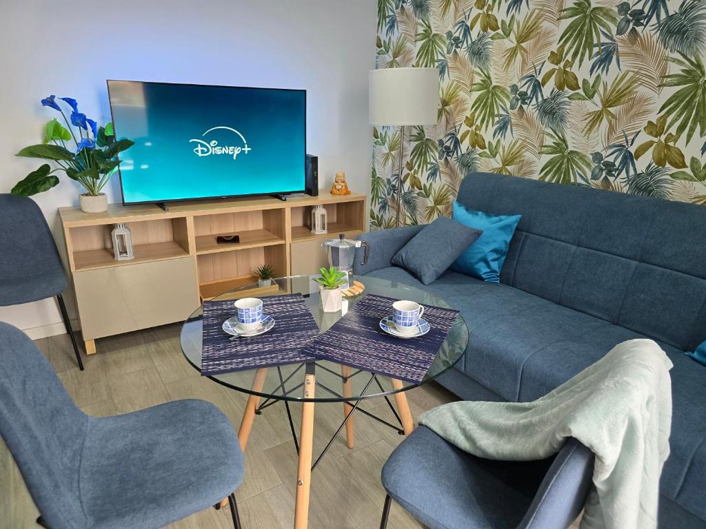 a living room with a couch and a tv at The Blue Calla in Las Palmas de Gran Canaria