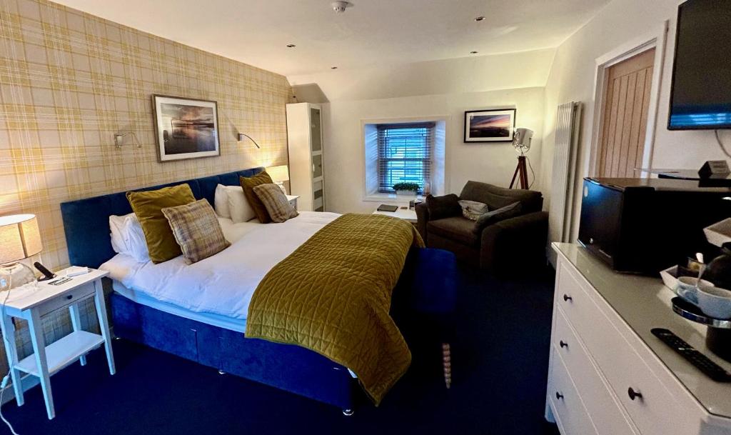 a bedroom with a large bed and a television at Lochindaal Hotel in Port Charlotte