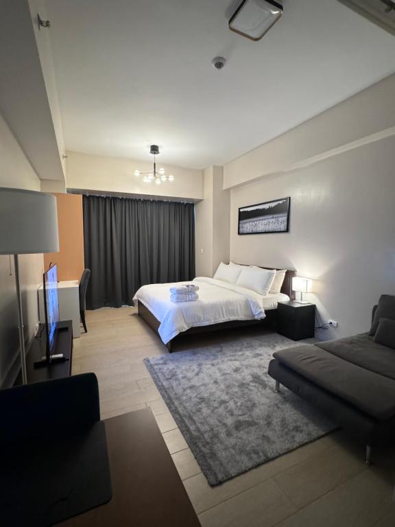 una habitación de hotel con una cama y un sofá en 81 Newport Blvd Cluster 4 Unit 10C by Rechelle Nunag, en Manila