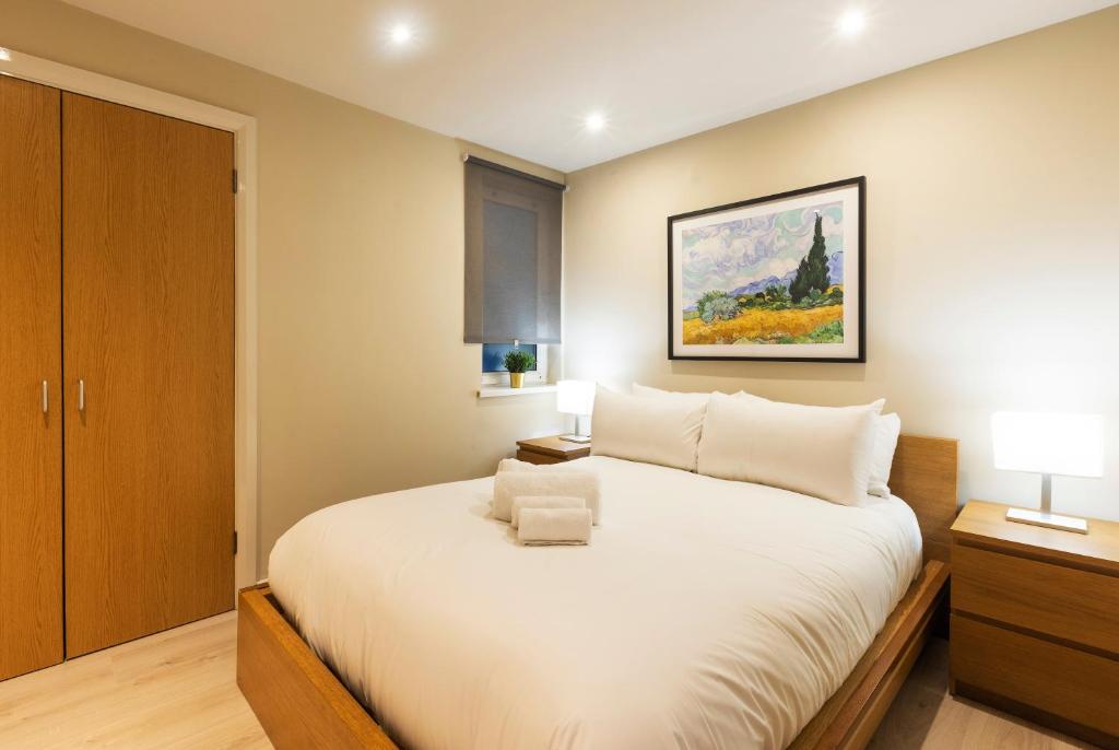 a bedroom with a white bed and a painting on the wall at The Van Gogh - Unique 1 bd -Gold Short Term Stays in Belfast