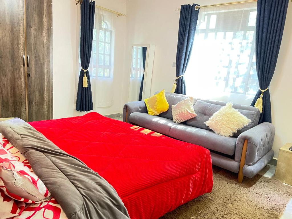 a living room with a couch and a red blanket at Aberdare Home in Othaya