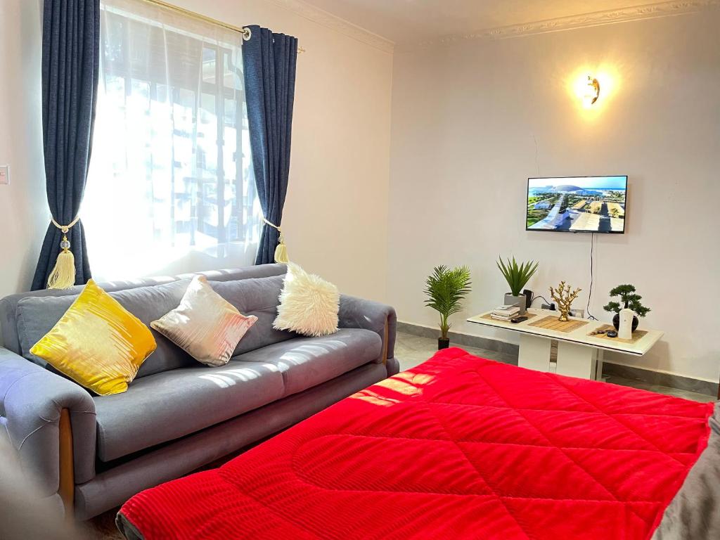 a living room with a couch and a red blanket at Aberdare Home in Othaya