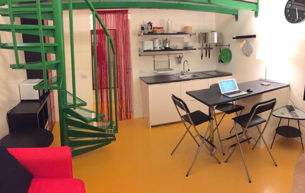 a kitchen with a table and chairs with a laptop on it at Duomo House in Milan