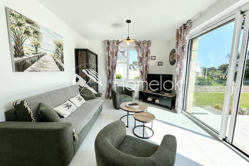 un salon avec un canapé et des chaises dans l'établissement Maison rénovée de standing - 100m des plages, à Ploemeur