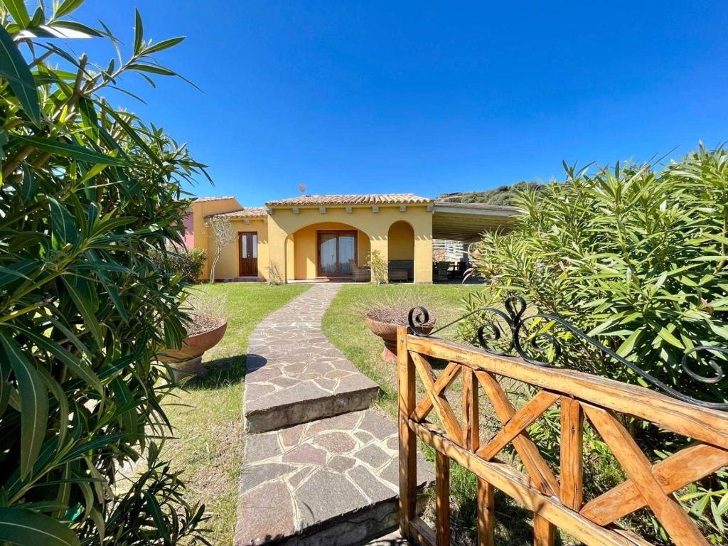 ein Haus mit einem Holzzaun und einem Gehweg in der Unterkunft Villa Privata Lux con piscina San Teodoro in Porto Ottiolu
