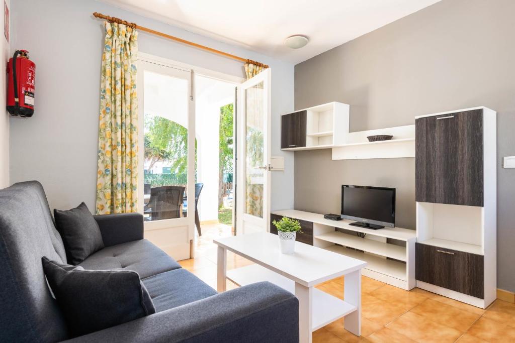 una sala de estar con un sofá y una mesa en Bungalows ses malves, en Cala en Blanes