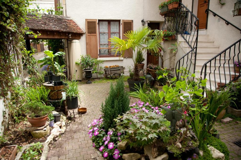 un jardin avec des fleurs et des plantes devant une maison dans l'établissement Maison accueillante à Auxerre de 50 m² avec jardin, à Auxerre