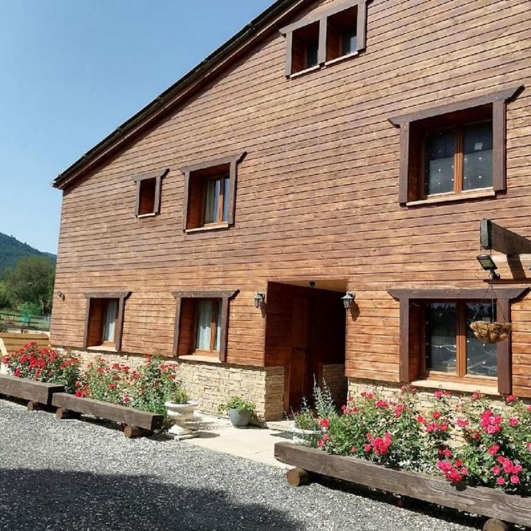 un bâtiment en bois avec des fleurs devant lui dans l'établissement Gîte T3 terrasse Chalet, à Puivert