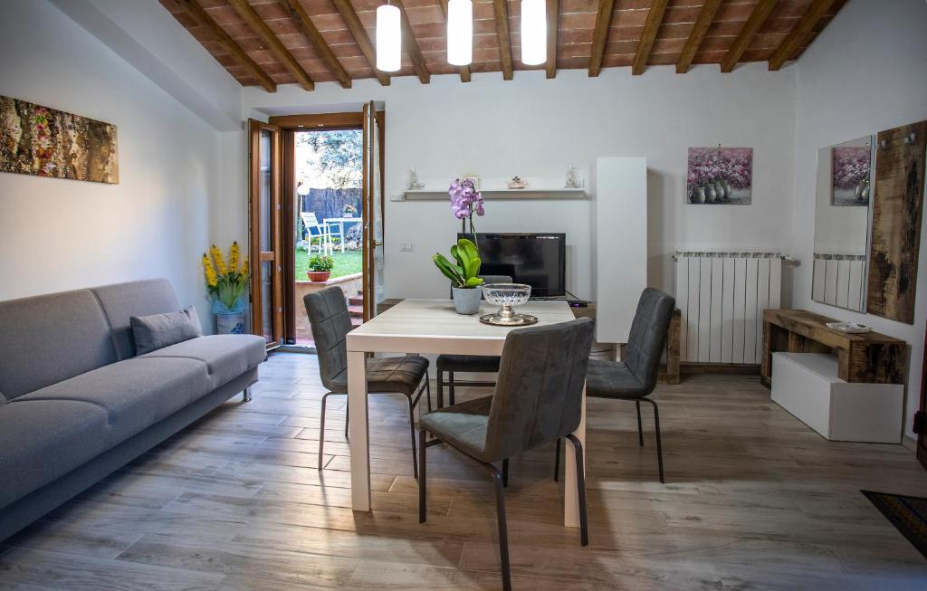 a living room with a table and chairs and a couch at appartamento l'olivo in San Gimignano