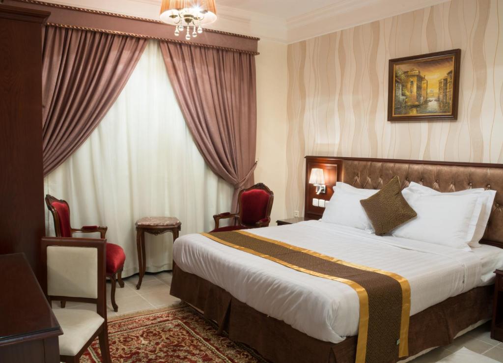 a hotel room with a large bed and a large window at Safari Hotel Apartment (Formerly Ewa Safari) in Jeddah