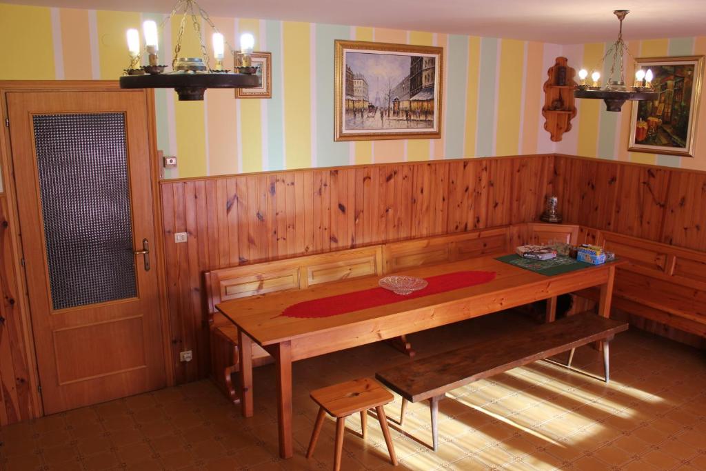 a dining room with a wooden table and a bench at Discover Italy in Tignes