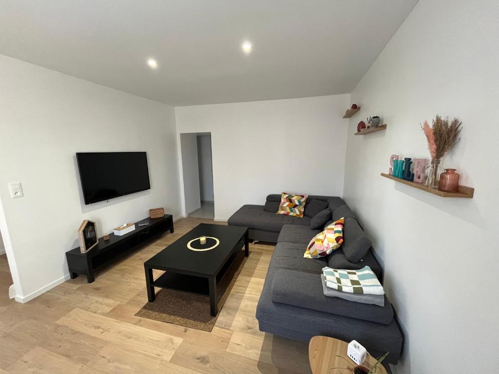 a living room with a couch and a table at Maison au calme in Villersexel