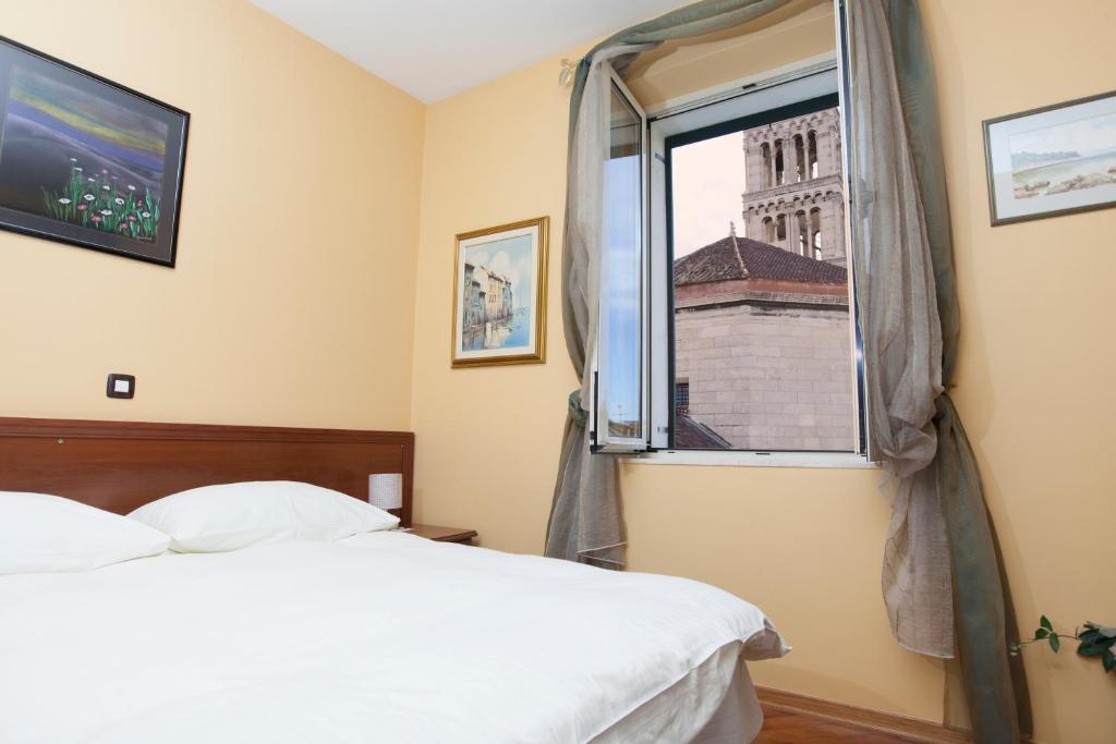 1 dormitorio con cama y ventana en Hotel Peristil, en Split