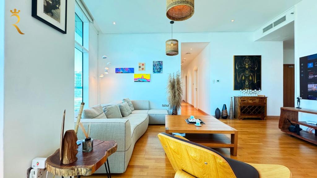 a living room with a couch and a table at Oceanview 2BR Bliss in Al Raha - Pool & Balcony Near Al Raha Beach in Abu Dhabi