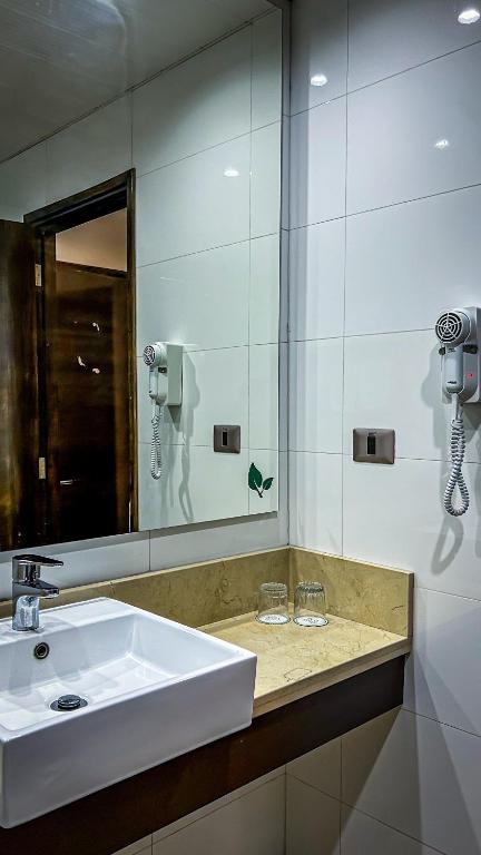 a bathroom with a white sink and a mirror at Ecohotel Talca in Talca