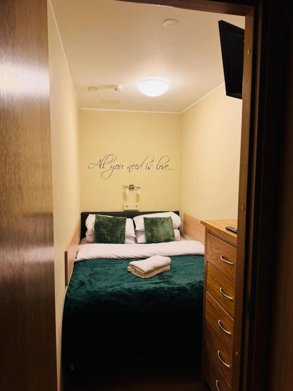 a bedroom with a bed with a green comforter at Luxury Suites Foorum by Rikas Hotels in Tallinn