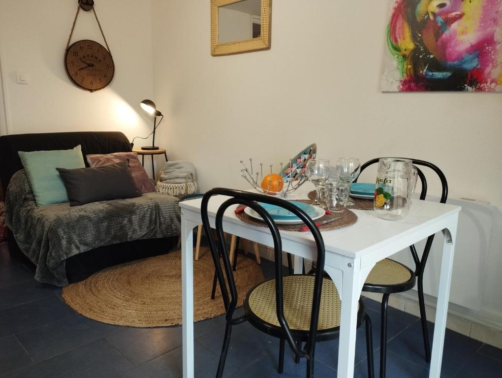 - une table et des chaises blanches dans une chambre avec un canapé dans l'établissement Le St Romain Proche Bugey & Lyon, à Saint-Romain-de-Jalionas