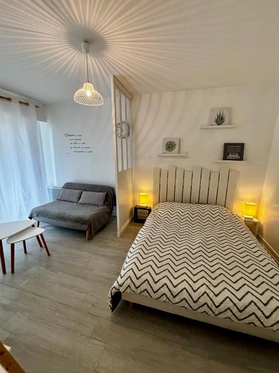 une chambre avec un grand lit et un canapé dans l'établissement Appartement avec balcon, proche CHU, château, Tramway, à Angers